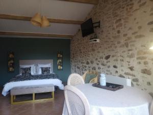 1 dormitorio con 2 camas, mesa y sillas en Studio Léonie, le cottage de l'étang, en Le Tablier