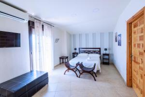 ein Zimmer mit einem Tisch und Stühlen und einem Bett in der Unterkunft La Posada de la Gula in Jarandilla de la Vera