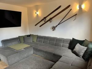 a living room with a couch and a clock on the wall at ALMHÜTTE Sunset - Flattnitz 1510m in Flattnitz