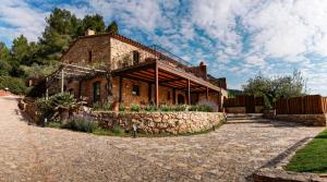 una antigua casa de ladrillo con una pared de piedra en Hotel Mas Mariassa en Pratdip