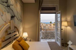 a bedroom with a bed and a view of the ocean at Matteotti Luxury Residence in Siracusa