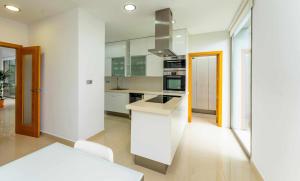 a kitchen with white cabinets and a white counter top at Luxury Villa Atlante con piscina climatiza privada in Santa Úrsula