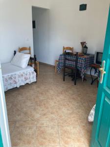 Pokój z łóżkiem, stołem i krzesłami w obiekcie AGKYRA Rooms (Love) w mieście Andros