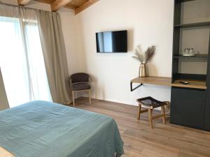 1 dormitorio con 1 cama y TV en la pared en Accommodation TRI MURVE, en Plomin