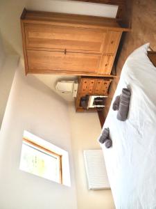 um quarto com uma cama com um armário de madeira e uma janela em Achill Alantic Dream em Derreen
