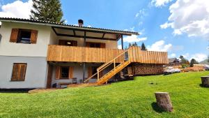 une maison avec une terrasse sur le côté dans l'établissement ALMHÜTTE Sunset - Flattnitz 1510m, à Flattnitz