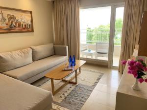 a living room with a couch and a coffee table at Hotel Bel Azur Thalasso & Bungalows in Hammamet