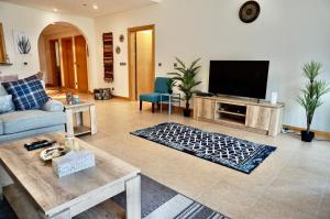 Luxury Apartment Palm Jumeirah في دبي: غرفة معيشة بها أريكة وتلفزيون