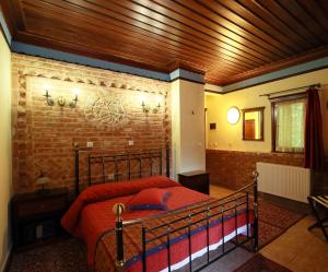 a bedroom with a bed and a brick wall at Hotel Nemesis in Stavroupoli