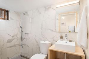 a white bathroom with a toilet and a sink at Sea Salt Apartments in Samos +96 photos