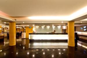 a lobby with a bar in a restaurant with columns at Fortuna Hotel in Bangkok