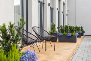 a row of chairs on a balcony with potted plants at DO DOMIS LOFT PALANGA in Palanga