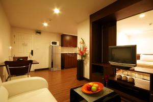 ein Wohnzimmer mit Sofa und Fernseher in einem Zimmer in der Unterkunft I Residence Hotel Sathorn in Bangkok