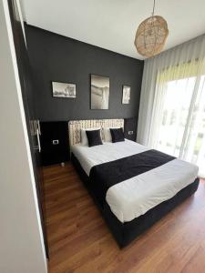 馬拉喀什的住宿－Superbe appart cosy résid privée avec piscine，一间卧室设有一张大床和黑色墙壁