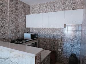 a kitchen with white cabinets and a stove top oven at Super corner in Ḩammām al Ghazzāz