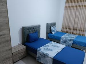 a bedroom with two beds and a mirror at Super corner in Ḩammām al Ghazzāz