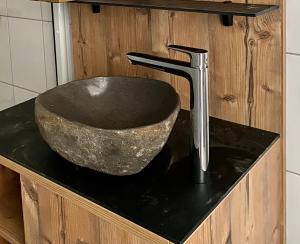 een wastafel in de badkamer met een stenen kom en een kraan bij Gjestegaarden Leiligheter in Beitostøl