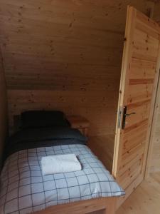 a small room with a bed in a wooden cabin at Chatka pod Krzemienna in Cisna