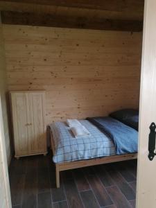 a bedroom with a bed in a wooden cabin at Chatka pod Krzemienna in Cisna