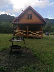 a swing in front of a log cabin at Chatka pod Krzemienna in Cisna