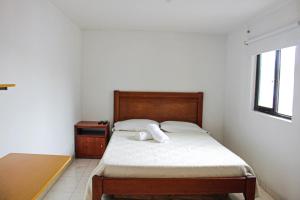 Dormitorio pequeño con cama y mesa en El Cable Hostal, en Manizales
