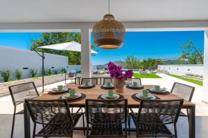 a dining room with a table and chairs and a large window at Villa Maris in Mlini
