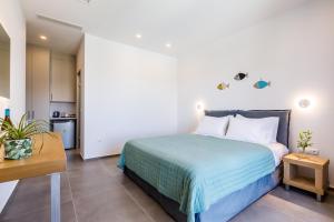 sypialnia z dużym łóżkiem i kuchnią w obiekcie Olia Green Residence w mieście Skopelos