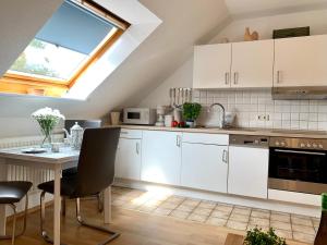 a kitchen with white cabinets and a table at Ferienwohnung "Ferieneck OG" in Sankt Peter-Ording