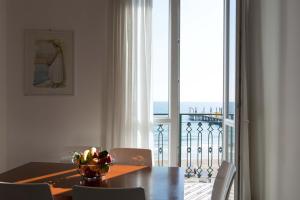 a dining room with a table and a view of the ocean at Appartamenti sul mare Alassio in Alassio