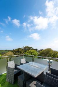 Un patio con una mesa y sillas en un balcón. en The Lighthouse Penthouse, Studio and Holiday Home, en St Ives