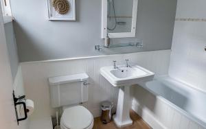 a white bathroom with a sink and a toilet at Brakestone Cottage in the heart of Port Isaac in Port Isaac +27 photos