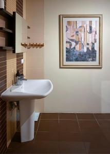 łazienka z umywalką i obrazem na ścianie w obiekcie Przestronny Apartament w Centrum w mieście Chełm