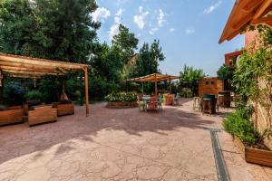 eine Terrasse mit Tischen, Stühlen und Sonnenschirmen in der Unterkunft La Posada de la Gula in Jarandilla de la Vera
