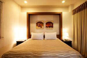 ein Schlafzimmer mit einem großen Bett und zwei Kissen in der Unterkunft I Residence Hotel Sathorn in Bangkok