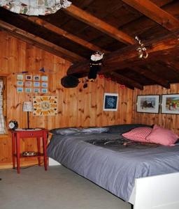 sypialnia z łóżkiem i drewnianą ścianą w obiekcie Chalet Gineprino w mieście Vallombrosa