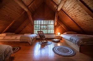 a attic room with two beds and a chair in it at Boutique House Vresje in Bohinjska Bistrica
