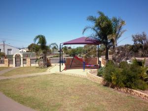 einen Spielplatz mit lila Baldachin in einem Park in der Unterkunft New Whyalla Hotel in Whyalla