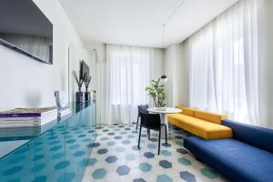 a living room with a yellow couch and a table at Villa Fedora Luxury Suites in Lucca