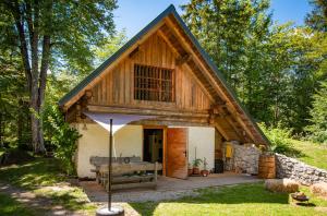a cabin in the woods with a gambrel roof at Boutique House Vresje in Bohinjska Bistrica