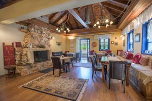 a living room with a stone fireplace and a couch at Arktouros Hotel in Monodendri