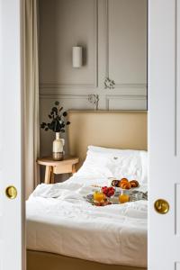 a bed with a tray of fruit on it at Seebay Hotel in Portonovo