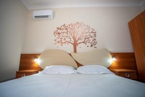 a bedroom with a bed with a tree on the wall at BB Domus Catanzaro in Catanzaro
