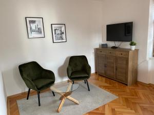 Duas cadeiras e uma mesa numa sala de estar com televisão em Kutna Hora perfect apartment em Kutná Hora