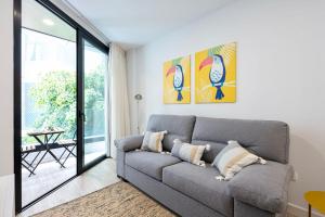 a living room with a couch and a large window at Famara Suites by AirNest in Las Palmas de Gran Canaria