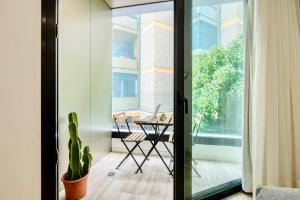 een kamer met een glazen schuifdeur met een tafel en een cactus bij Famara Suites by AirNest in Las Palmas de Gran Canaria