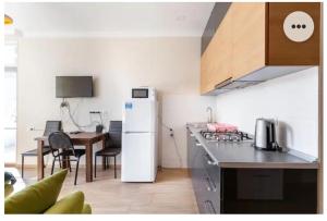 a kitchen with a white refrigerator and a table at 1BR Cozy apartment in Batumi