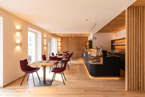 un restaurante con mesas, sillas y una barra en Am Brunnen Apartments, en Naz-Sciaves