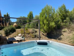 a jacuzzi tub in a yard with a table at Les Hauts de la Pinède - Villa avec Piscine, Jacuzzi et Boulodrome privatifs in Thèzan-lès-Béziers