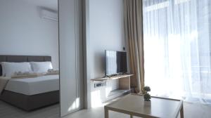 a bedroom with a bed and a television and a table at Silver Beachfront Becici in Bečići