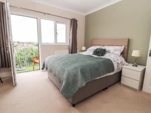a bedroom with a bed and a large window at Ty Uchaf in Rhyl